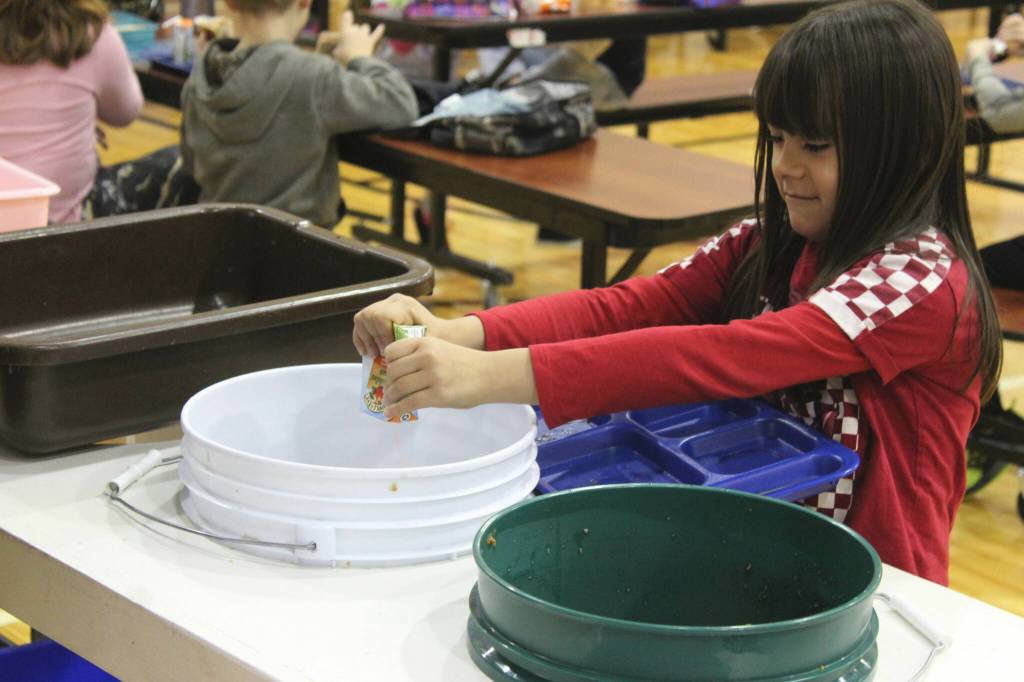 Grecia Martinez Sandstrom, second grade, pours out orange juice during lunch at Sterling Elementary School on Thursday, Nov. 10, 2022, in Sterling, Alaska. (Ashlyn OHara/Peninsula Clarion)