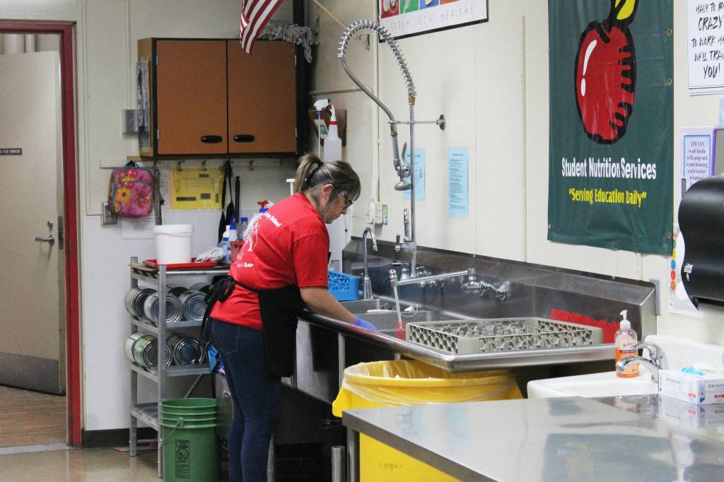 Toni Buchanan washes dishes during lunch time in the cafeteria at Sterling Elementary School on Thursday, Nov. 10, 2022, in Sterling, Alaska. (Ashlyn OHara/Peninsula Clarion)