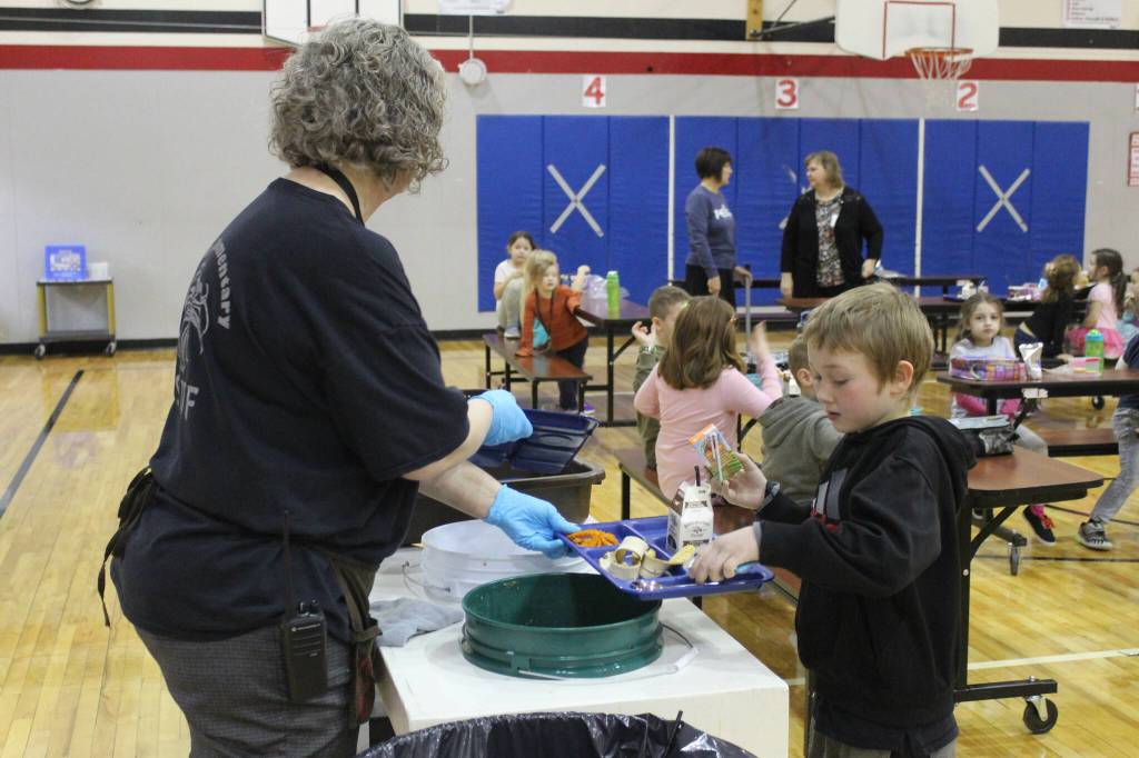 Principal Denise Kelly helps Lucas Edwards, second grade, dispose of lunch materials at Sterling Elementary School on Thursday, Nov. 10, 2022, in Sterling, Alaska. (Ashlyn OHara/Peninsula Clarion)