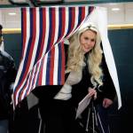 U.S. Senate candidate Kelly Tshibaka, a Republican, emerges from a voting booth with her son, Joseph, after casting her ballot Tuesday, Nov. 8, 2022, in Anchorage, Alaska. Tshibaka is trying to unseat U.S. Sen. Lisa Murkowski, also a Republican, in the general election. Also in the race is Democrat Pat Chesbro. (AP Photo/Mark Thiessen)