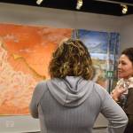 Charlotte Coots speaks in front of She Rides Her Story Like a Cloud, one of her pieces, at the Mural 2022 opening reception at Kenai Art Center in Kenai, Alaska, on Thursday, Nov. 10, 2022. (Jake Dye/Peninsula Clarion)