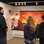 Jason Ramirez speaks in front of his piece Got Space? to attendees of the Mural 2022 opening reception at the Kenai Art Center in Kenai, Alaska, on Thursday, Nov. 10, 2022. (Jake Dye/Peninsula Clarion)