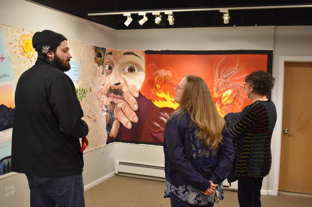 Jason Ramirez speaks in front of his piece Got Space? to attendees of the Mural 2022 opening reception at the Kenai Art Center in Kenai, Alaska, on Thursday, Nov. 10, 2022. (Jake Dye/Peninsula Clarion)