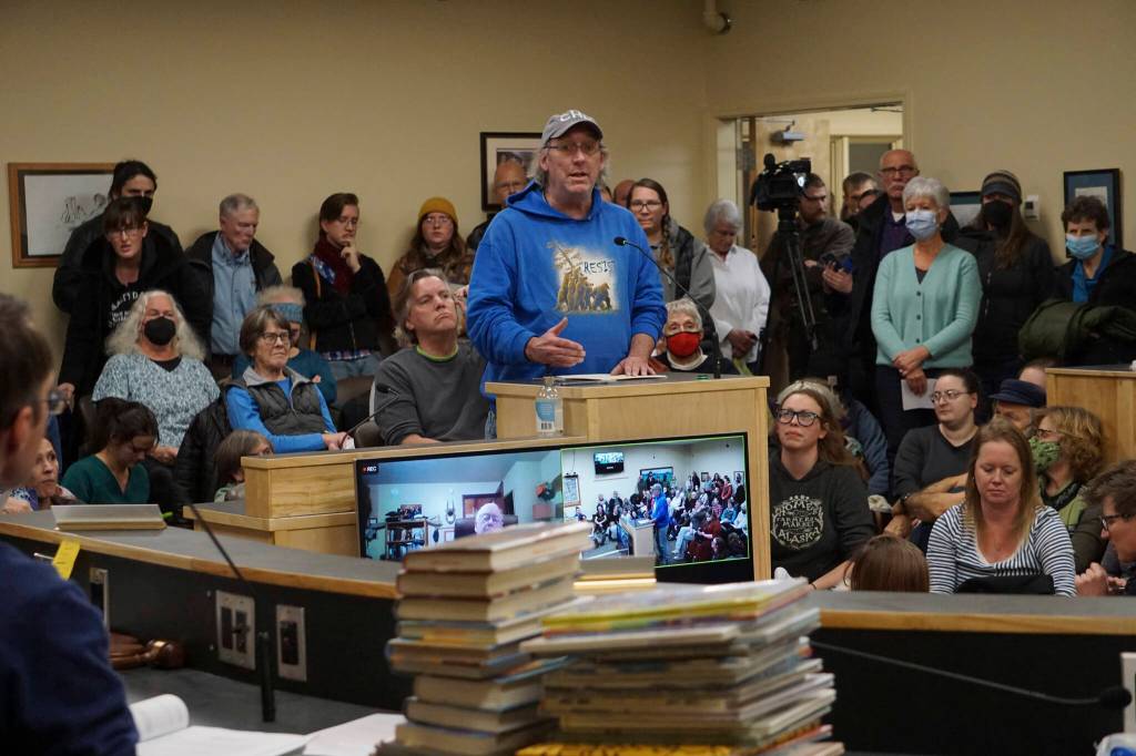 David Lewis speaks at at the meeting of the Library Advisory Board on Nov. 15, 2022, in the Cowles Council Chambers at Homer City Hall in Homer, Alaska. A pile of books a citizens group has LGBQT+ content that it has asked to be removed from the childrens section of the Homer Public Library lies on the table in the foreground. (Photo by Michael Armstrong/Homer News)