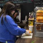 Abbi Suprick prepares a bagel at Everything Bagels in Soldotna, Alaska, on Thursday, Nov. 17, 2022. (Jake Dye/Peninsula Clarion)