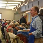 Mountain View Elementary School Principal Karl Kircher distributes dinners to seniors on Friday, Nov. 18, 2022, at the Area-Wide Senior Dinner at Kenai Seniors Center in Kenai, Alaska. (Jake Dye/Peninsula Clarion)