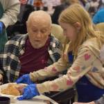 Roy Williams receives a dinner from a volunteer on Friday, Nov. 18, 2022, at the Area-Wide Senior Dinner at Kenai Seniors Center in Kenai, Alaska. (Jake Dye/Peninsula Clarion)