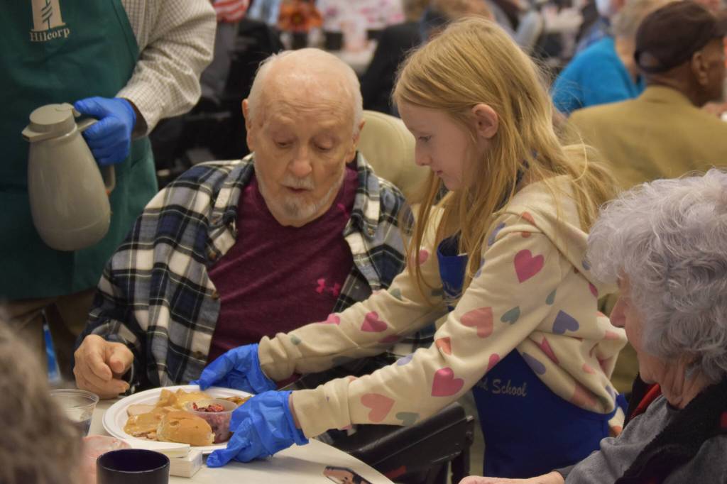 Roy Williams receives a dinner from a volunteer on Friday, Nov. 18, 2022, at the Area-Wide Senior Dinner at Kenai Seniors Center in Kenai, Alaska. (Jake Dye/Peninsula Clarion)