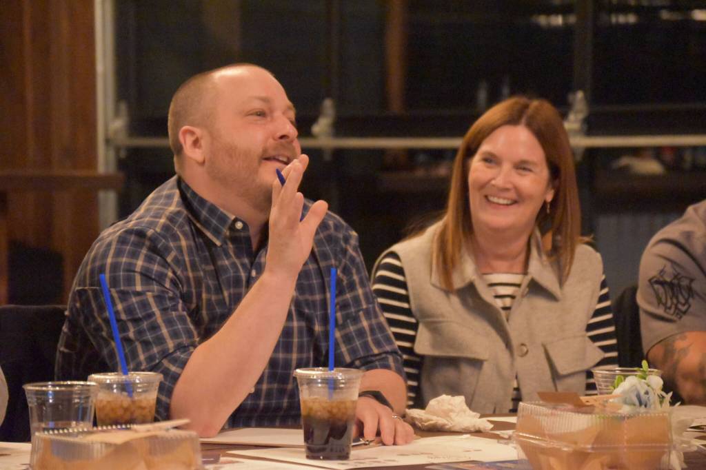 Tyson Cox and Tanya Lautaret, two of the sharks, are seen; Cox questions a contestant at the Spark Soldotna Shark Tank Event on Friday, Nov. 18, 2022, at The Lone Moose Lodge in Soldotna, Alaska. (Jake Dye/Peninsula Clarion)