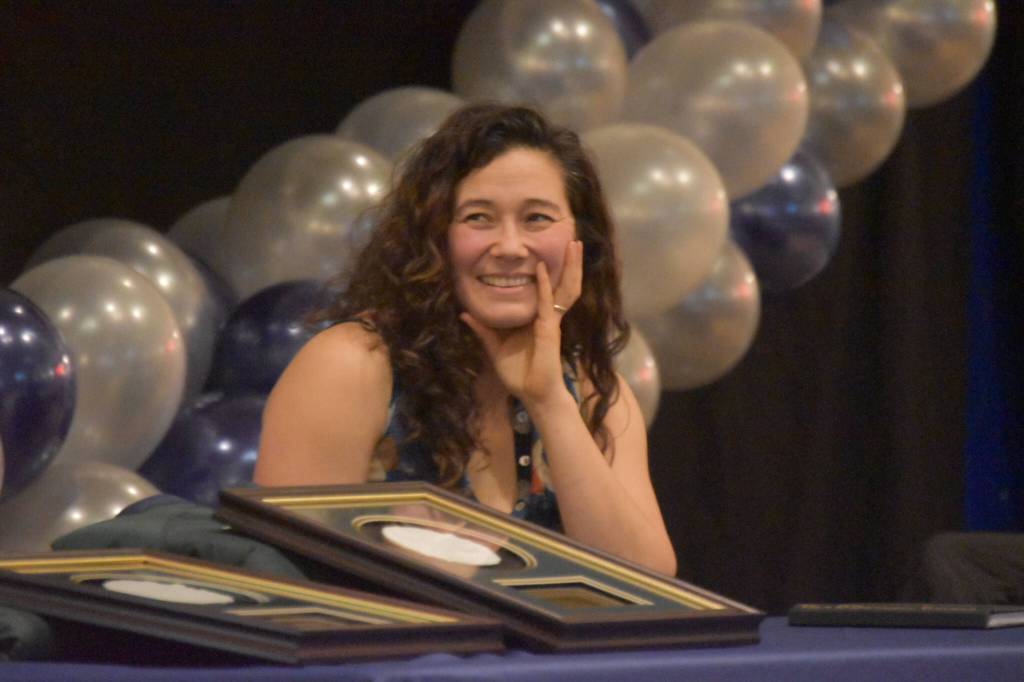 Tela ODonnell-Bacher laughs at a story being told by Neldon Gardner while both were being inducted to the National Wrestling Hall of Fame following the duel wrestling meet on Tuesday, Nov. 22, 2022, at Soldotna High School in Soldotna, Alaska. (Jake Dye/Peninsula Clarion)