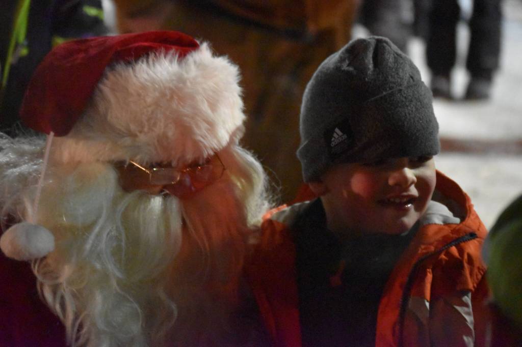Santa Claus is seen with a child at Christmas Comes to Kenai festivities at the Kenai Chamber of Commerce/Visitor Center in Kenai, Alaska on Friday, Nov. 25, 2022. (Jake Dye/Peninsula Clarion)