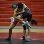 Kenais Delen Byrd and Nikiskis Niles Broussard tangle work each other during a dual meet on Tuesday, Nov. 29, 2022, at Kenai Central High School in Kenai, Alaska. (Jake Dye/Peninsula Clarion)