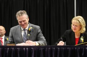 Gov. Mike Dunleavy, seated left, and Lt. Gov. Nancy Dahlstrom sign their oaths of office during the inauguration ceremony, Monday, Dec. 5, 2022, in Anchorage, Alaska. Dunleavy, a Republican, last month became the first Alaska governor since Democrat Tony Knowles in 1998 to win back-to-back terms. (AP Photo/Mark Thiessen)