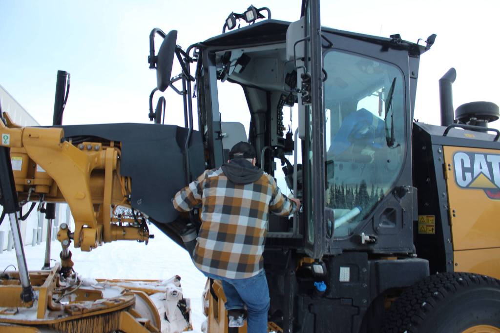Kenai City Streets foreman Curt Wagoner climbs inside of a city grader on Wednesday, Dec. 7, 2022, in Kenai, Alaska. (Ashlyn OHara/Peninsula Clarion)