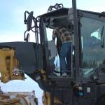 Kenai City Streets foreman Curt Wagoner stands inside of a city grader on Wednesday, Dec. 7, 2022, in Kenai, Alaska. (Ashlyn OHara/Peninsula Clarion)