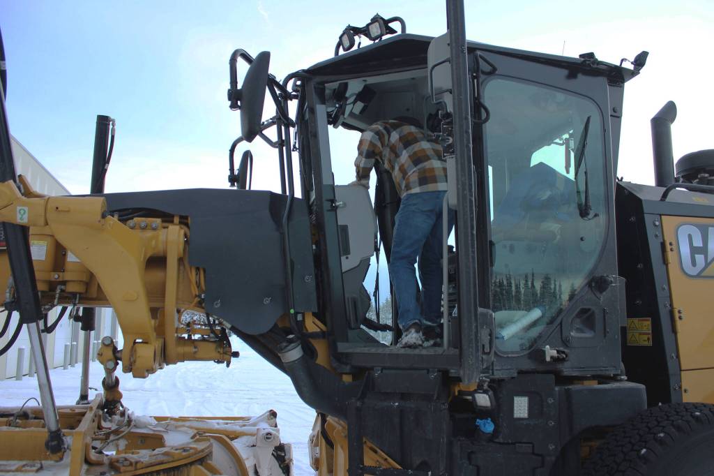 Kenai City Streets foreman Curt Wagoner stands inside of a city grader on Wednesday, Dec. 7, 2022, in Kenai, Alaska. (Ashlyn OHara/Peninsula Clarion)
