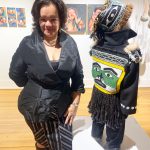 Photo by Christina Whiting 
Juneau artist Lily Wooshkindein Da.Aat poses with her work, Little Watchman, at the opening this month of the exhibit Mother at Bunnell Street Arts Center.
