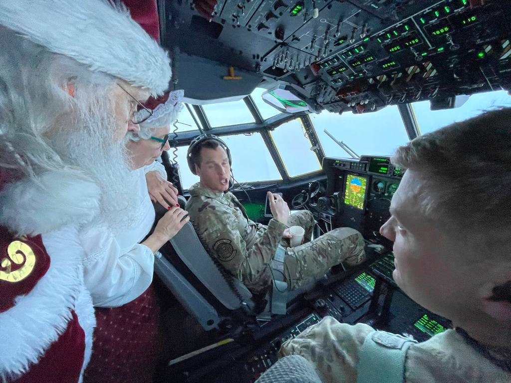 Santa and Mrs. Claus chat with the flight crew of an Alaska National Guard cargo plane while en route to Nuiqsut, Alaska, on Tuesday, Nov. 29, 2022. Operation Santa Claus, the guards outreach program, attempts to bring Santa and Mrs. Claus and gifts to children in two or three Alaska Native villages each year. (AP Photo/Mark Thiessen)