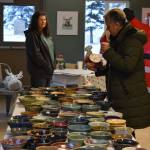 An attendee checks out the ceramic soup bowls during Bark, Block and Bowl on Saturday, Dec. 10, 2022, at the Kenai Peninsula Food Bank in Soldotna, Alaska. (Jake Dye/Peninsula Clarion)
