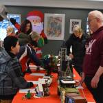 Greg Meyer speaks to a potential buyer of the Lego sets he built as they are put on auction during Bark, Block and Bowl on Saturday, Dec. 10, 2022, at the Kenai Peninsula Food Bank in Soldotna, Alaska. (Jake Dye/Peninsula Clarion)