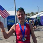 Jon Iannaccone waves an American flag while wearing a medal after completing the World Triathlon Championships in Abu Dhabi, United Arab Emirates, Nov. 26, 2022. (Photo courtesy Jon Iannaccone)