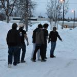 The six members of Kenai Central's League of Legends team complete a weekly pregame ritual "to touch grass" ahead of the League of Legends ASAA State Championship Match on Tuesday, Dec. 13, 2022 at Kenai Central High School in Kenai, Alaska. In internet and video game culture, people are told to touch grass to disconnect from the digital worlds they're spending time in. (Jake Dye/Peninsula Clarion)
