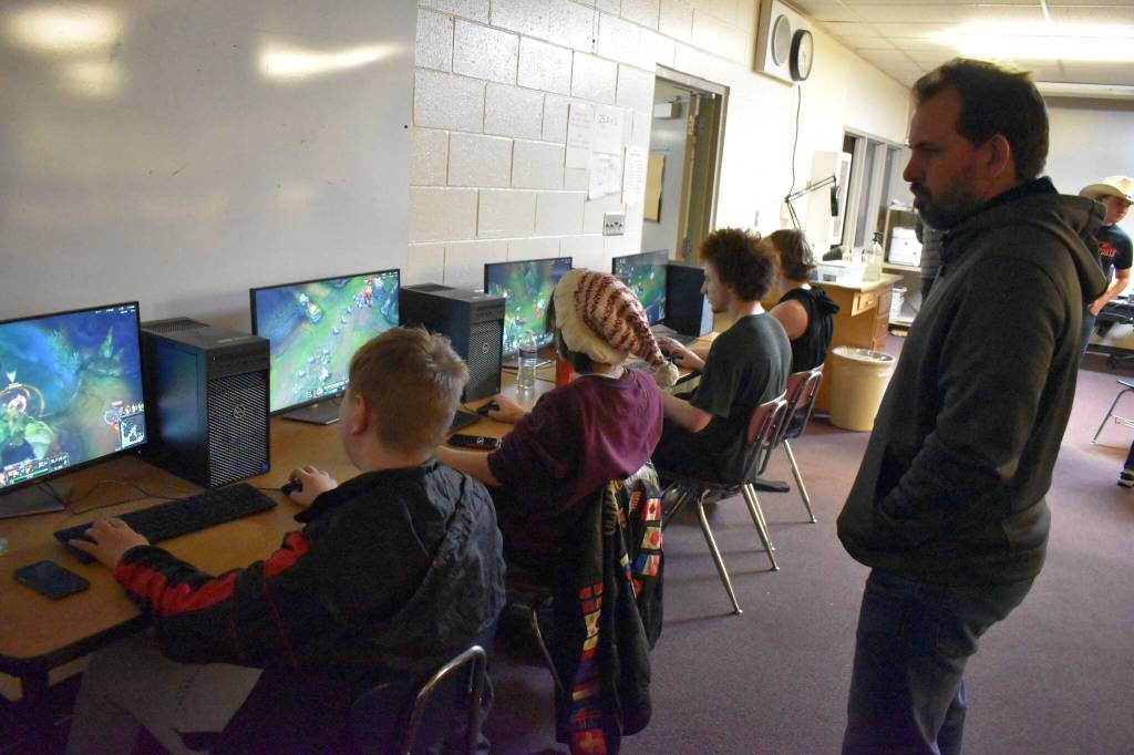 Roman Dunham, Cody Good, Silas Thibodeau and Kage Adkins compete while Coach Shane Lopez watches during the League of Legends ASAA State Championship Match on Tuesday, Dec. 13, 2022 at Kenai Central High School in Kenai, Alaska. (Jake Dye/Peninsula Clarion)