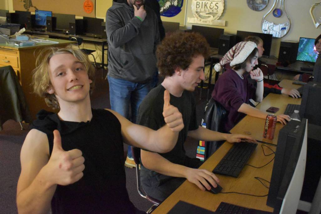 Kage Adkins keeps his teammates spirits up in the moments after their screens flashed the word "Defeat" in red during the League of Legends ASAA State Championship Match on Tuesday, Dec. 13, 2022 at Kenai Central High School in Kenai, Alaska. (Jake Dye/Peninsula Clarion)