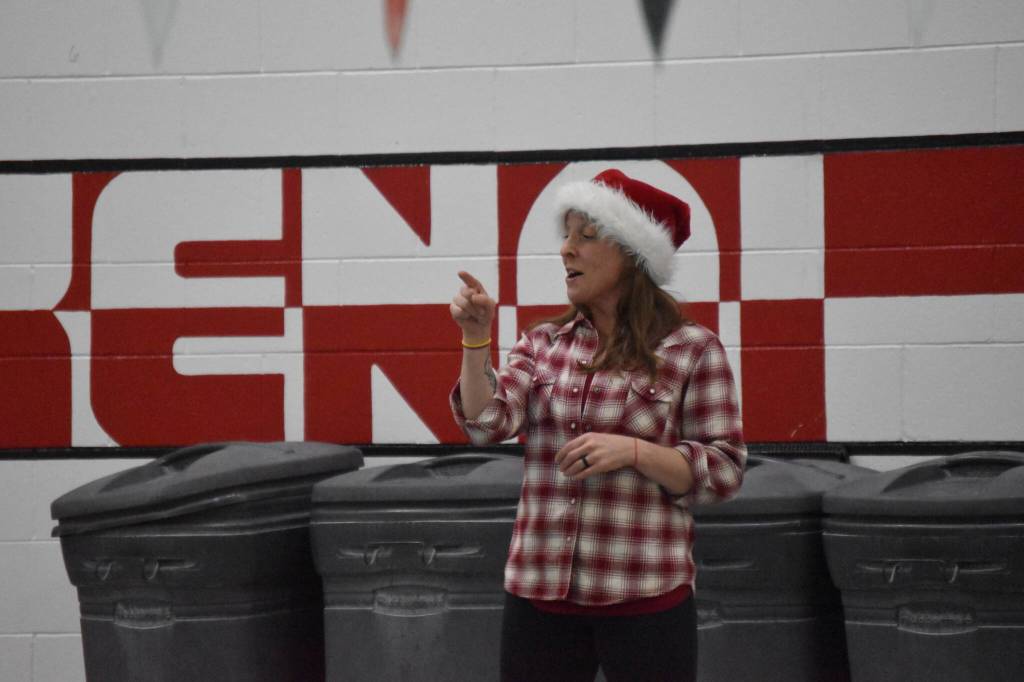 Angie Brennan chats with the swimmers during a Top of the World Swimming practice on Wednesday, Dec. 14, 2022, at Kenai Central High School in Kenai, Alaska. (Jake Dye/Peninsula Clarion)