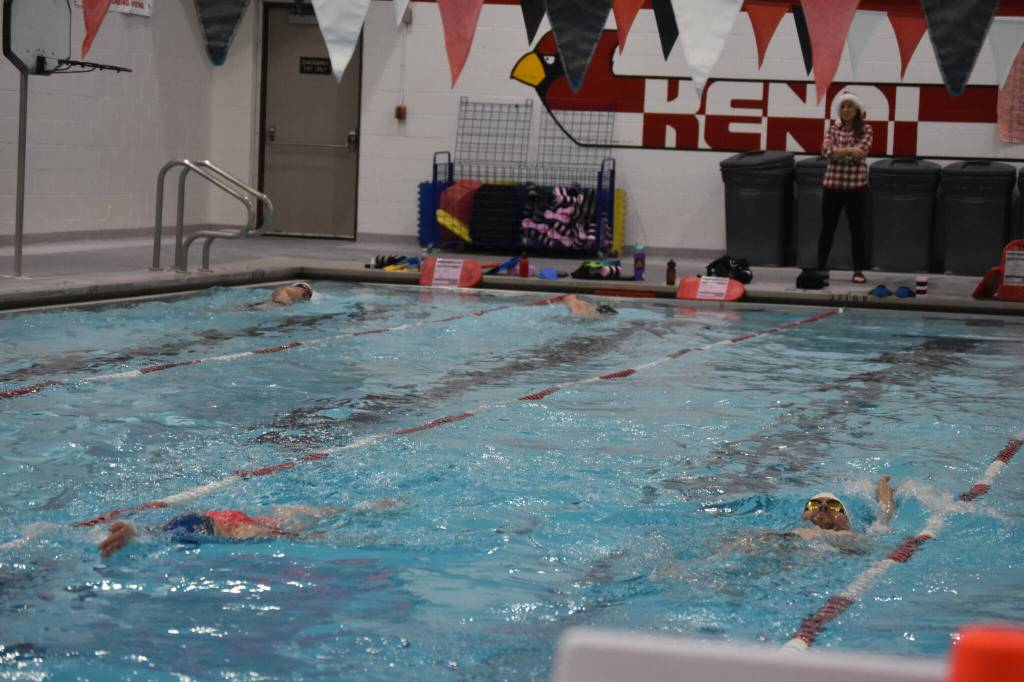 Coach Angie Brennan watches as swimmers complete a workout set during a Top of the World Swimming practice on Wednesday, Dec. 14, 2022, at Kenai Central High School in Kenai, Alaska. (Jake Dye/Peninsula Clarion)