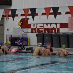 Swimmers gather at the wall to receive their next workout set from Coach Angie Brennan during a Top of the World Swimming practice on Wednesday, Dec. 14, 2022, at Kenai Central High School in Kenai, Alaska. (Jake Dye/Peninsula Clarion)