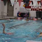 Coach Angie Brennan watches as swimmers complete a workout set during a Top of the World Swimming practice on Wednesday, Dec. 14, 2022, at Kenai Central High School in Kenai, Alaska. (Jake Dye/Peninsula Clarion)