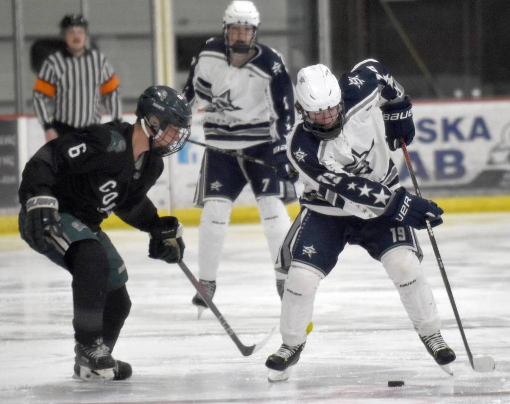 Colonys Robbie Yundt and Soldotnas Marshall DeRaeve battle for the puck Saturday, Jan. 7, 2023, at the Soldotna Regional Sports Complex in Soldotna, Alaska. (Photo by Jeff Helminiak/Peninsula Clarion)
