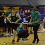 Dakota Butler hangs from a wooden pole by only his wrist as he performs the wrist carry during the Kahtnuhtana Hey Chiula NYO Invitational on Saturday, Jan. 14, 2023, at Kenai Middle School in Kenai, Alaska. Butler held on for more than 200 feet, claiming the gold medal in the event. (Jake Dye/Peninsula Clarion)