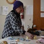 A volunteer passes gummies and pudding to a young girl at Kenai United Methodist Food Pantry in Kenai, Alaska, on Monday, Jan. 23, 2022. (Jake Dye/Peninsula Clarion)