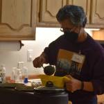 A volunteer ladles Hungarian mushroom soup donated by Odies at Kenai United Methodist Food Pantry in Kenai, Alaska, on Monday, Jan. 23, 2022. (Jake Dye/Peninsula Clarion)