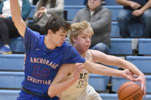 JD McGee of Anchorage Christian Schools knocks the ball away from Soldotna's Jakob Brown on Wednesday, Jan. 25, 2023, at Soldotna High School in Soldotna, Alaska. (Photo by Jeff Helminiak/Peninsula Clarion)