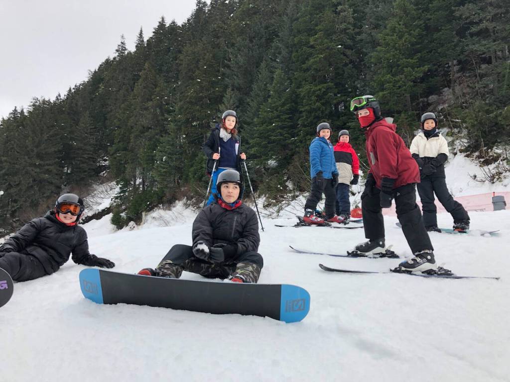 Seward Middle School students stand, sit, and smile for a photo at Alyeska Resort in Girdwood, Alaska, on Jan. 24, 2023. (Photo courtesy Myla Lijemark)