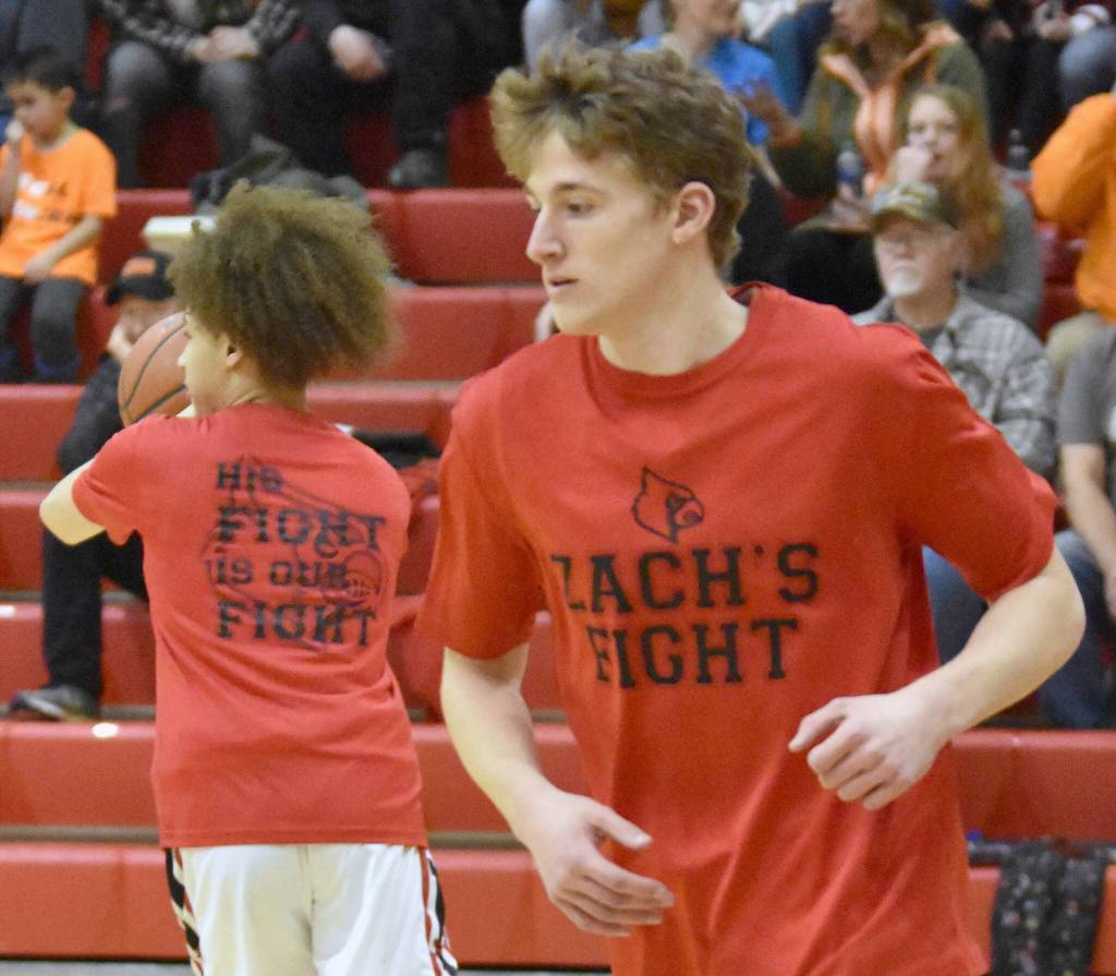 Kenai players warm up at the girls halftime wearing T-shirts referencing teammate Zach Armstrong, a sophomore on the team. Armstrong was diagnosed with leukemia in November and the Tuesday, Jan. 31, 2023, game against Nikiski at Kenai Central High School was a fundraiser for the Armstrong family. (Photo by Jeff Helminiak/Peninsula Clarion)