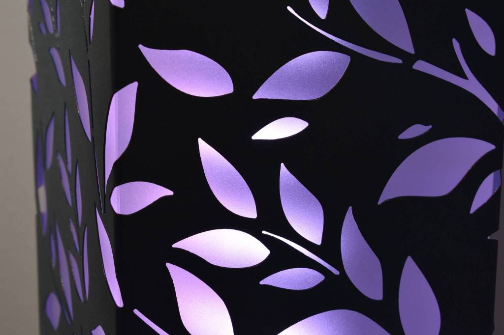 The sihouette of branches and leaves are illuminated on a sculpture Tuesday, Jan. 31, 2023, at the Kenai Art Center, in Kenai, Alaska, as part of Metalwork & Play. (Jake Dye/Peninsula Clarion)