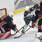 Kenai Central goalie Evyn Witts makes a save on Soldotna's Ezekiel Miller as Kenai's Reagan Graves and Logan Mese defend Friday, Jan. 27, 2023, at the Soldotna Regional Sports Complex in Soldotna, Alaska. (Photo by Jeff Helminiak/Peninsula Clarion)