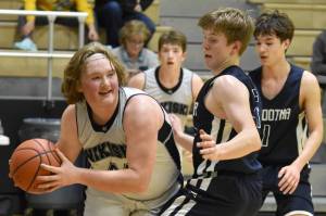 Nikiski's Charlie Chamberlain drives on Soldotna's Andrew Pieh on Tuesday, Feb. 7, 2023, at Nikiski High School in Nikiski, Alaska. (Photo by Jeff Helminiak/Peninsula Clarion)