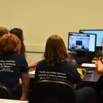The members of the Soldotna High School Battle of the Books team, Lyndzi Gaucin, Leihla Harrison, Aidan Bon, Emma Knowles and coach Nicole Jensen gather around a computer as they introduce themselves over Zoom to the other teams before the Kenai Peninsula Borough School District High School Battle of the Books Final on Tuesday, Feb. 7, 2023 at Soldotna High School in Soldotna, Alaska. (Jake Dye/Peninsula Clarion)