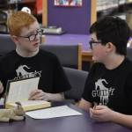 Alan Hack and Oscar Marcou discuss the evidence that they will present to support a challenge issued during Kenai Peninsula Borough School District Middle School Battle of the Books competition on Thursday, Feb. 9, 2023, at Kenai Middle School in Kenai, Alaska. The challenge would ultimately be declared successful. (Jake Dye/Peninsula Clarion)