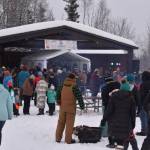 Snow falls as attendees of Frozen RiverFest gather around the stage and listen to The Ridgeway Rounders on Saturday, Feb. 18, 2023 at Soldotna Creek Park in Soldotna, Alaska. (Jake Dye/Peninsula Clarion)