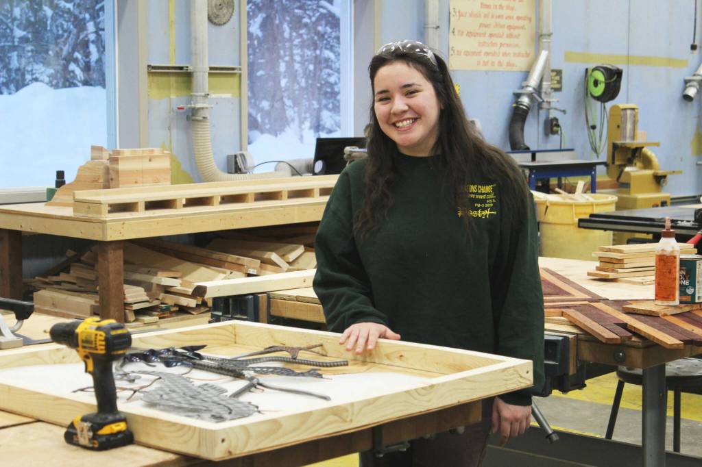 Kenai Central High School senior Jorgi Phillips stands next to a wooden box she made to transport metal art on Wednesday, Feb. 22, 2023 in Kenai, Alaska. (Ashlyn OHara/Peninsula Clarion)