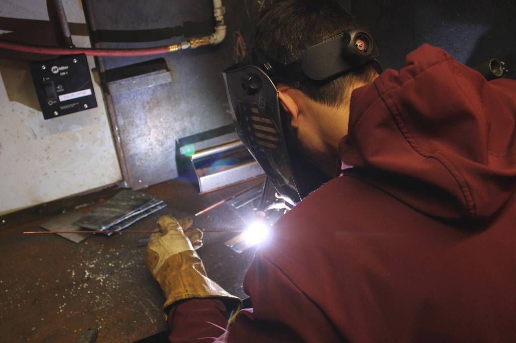 Kenai Peninsula Middle College Senior Lucas Ermold works inside a welding booth at Soldotna High School on Wednesday, Feb. 22, 2023 in Soldotna, Alaska. (Ashlyn OHara/Peninsula Clarion)