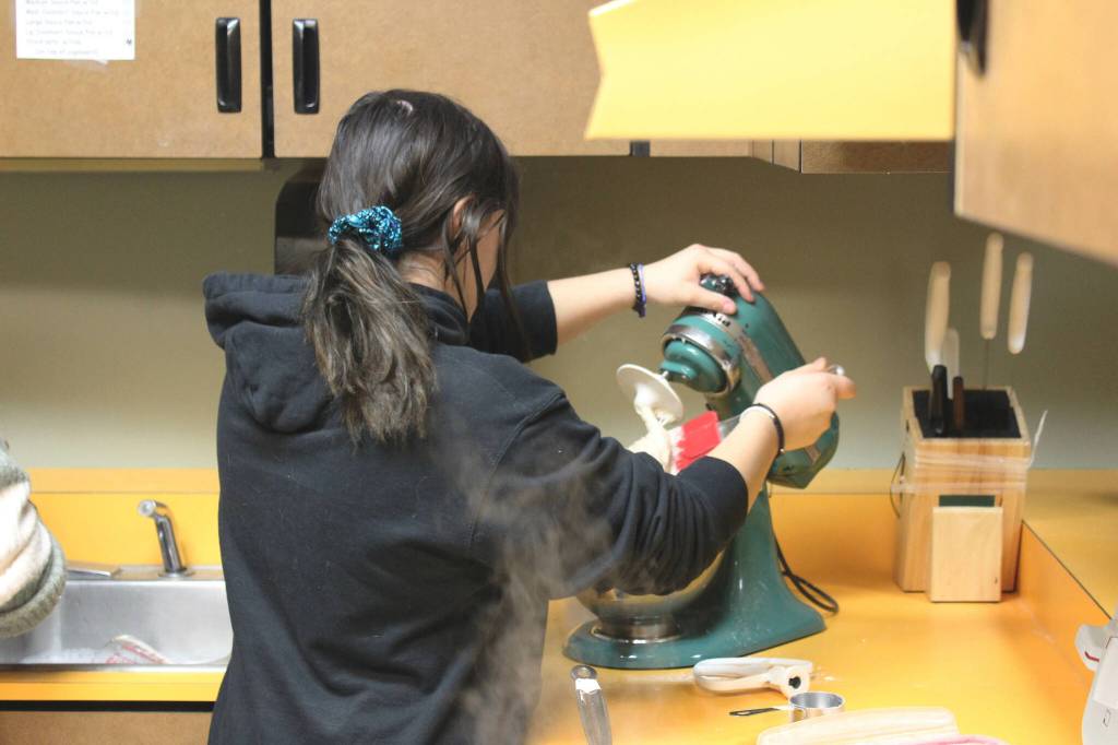 Maddie Cazares mixes pretzel dough during a foods class at Kenai Central High School on Wednesday, Feb. 22, 2023 in Kenai, Alaska. (Ashlyn OHara/Peninsula Clarion)