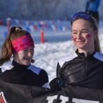Kenai Central skiers Mya Taylor and Emily Moss celebrate finishing the girls 4x3.5-kilometer relay, their last race at the ASAA State Nordic Ski Championships at Kincaid Park in Anchorage, Alaska, on Saturday, Feb. 25, 2023. (Jake Dye/Peninsula Clarion)