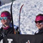 Kenai Central skiers Lynnea Hack and Madison McDonald celebrate finishing the girls 4x3.5-kilometer relay, their last race at the ASAA State Nordic Ski Championships at Kincaid Park in Anchorage, Alaska, on Saturday, Feb. 25, 2023. (Jake Dye/Peninsula Clarion)